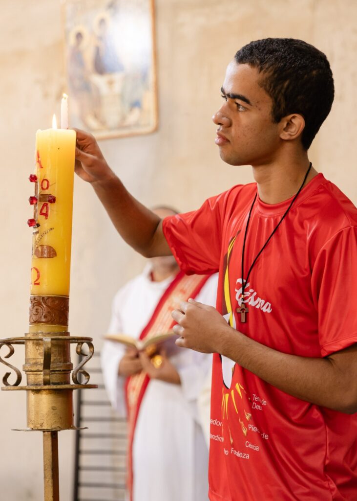 Ein junger mensch mit einer osterkerze